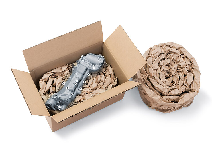 Ein Karton mit einem Bauteil und Papierpolstern aus aufgerollten Papierpolstersträngen