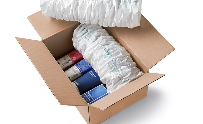 Ein Karton mit Kosmetikprodukten und weißen Papierpolstern